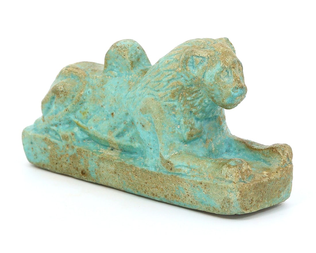 An Antique Egyptian Revival Faience Sphinx Sculpture, Early 20th Century: This faience sculpture of a sphinx is a remarkable testament to the Egyptian Revival style, embodying the allure and mystique of ancient Egypt's mythology. The vibrant turquoise glaze and detailed car