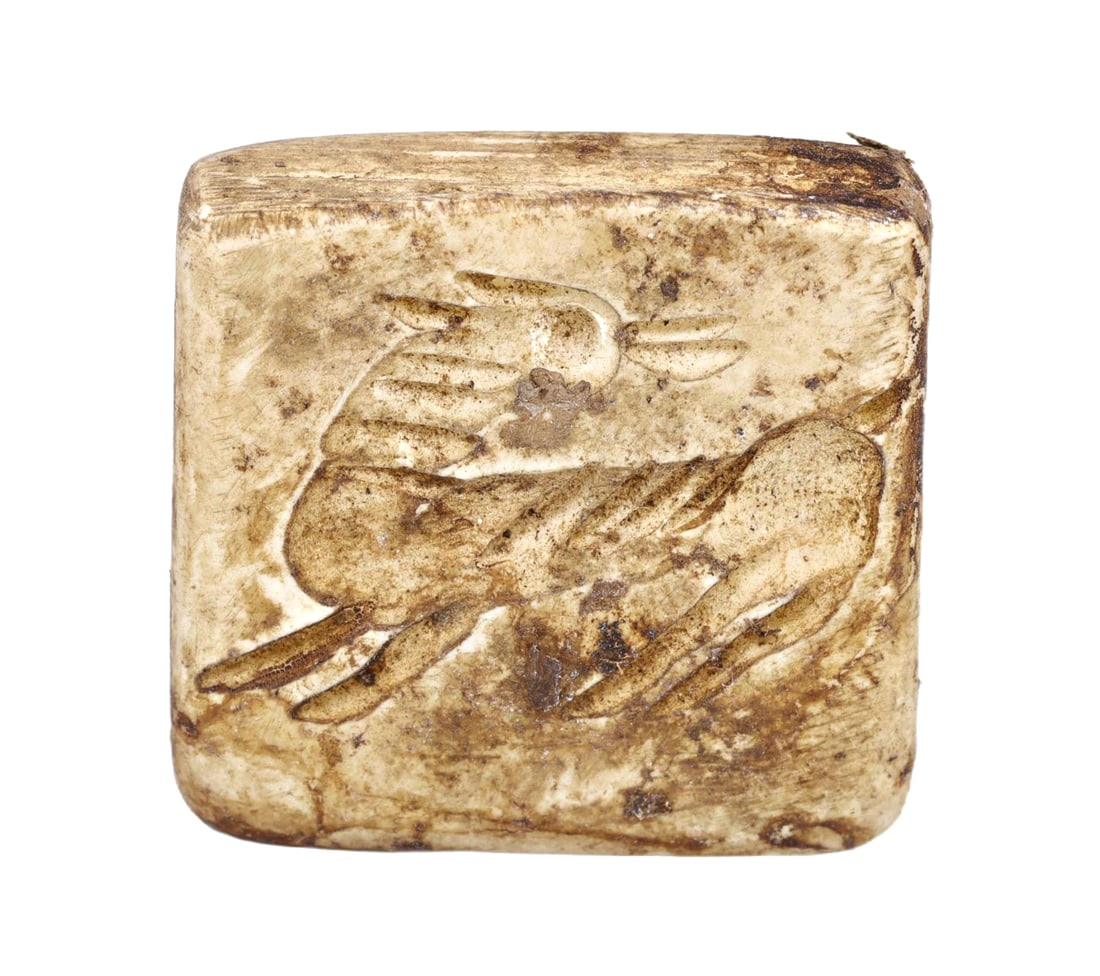 An Ancient Persian Bone Dice with Dove Carving, 1st Millennium BCE: This intricately carved bone dice from ancient Persia, dated to the 1st millennium BCE, features a skillfully rendered dove, symbolizing peace and spirituality in many ancient cultures. Such artifacts