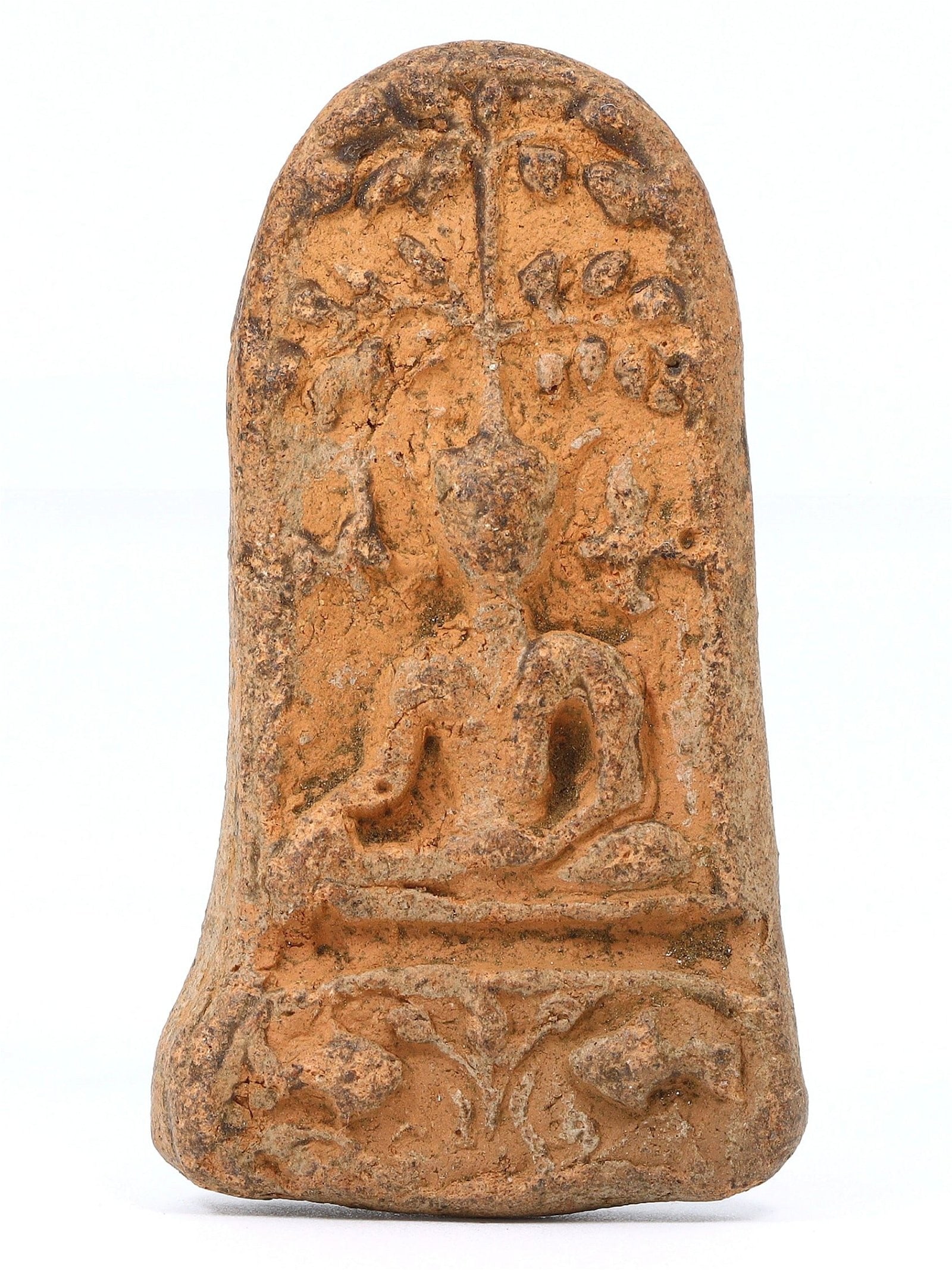 An Ancient Southeast Asian Terracotta Buddha Votive Tablet, Pre-15th Century: This terracotta votive tablet from pre-15th century Southeast Asia features an intricately molded Buddha amidst a backdrop of foliage, an art form dedicated to merit-making and spiritual commemoration