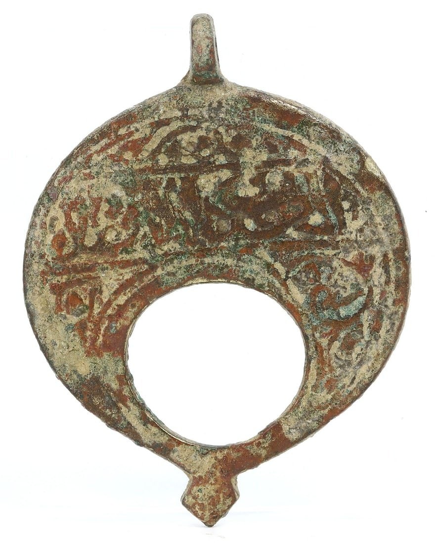An Ancient Byzantine Bronze Lunar Amulet, Circa 5th-7th Century CE: This lunar-shaped bronze amulet, measuring 5 x 4 cm, is identified as a piece from the Byzantine period, likely dating between the 5th and 7th centuries CE. The crescent shape was a common motif in By