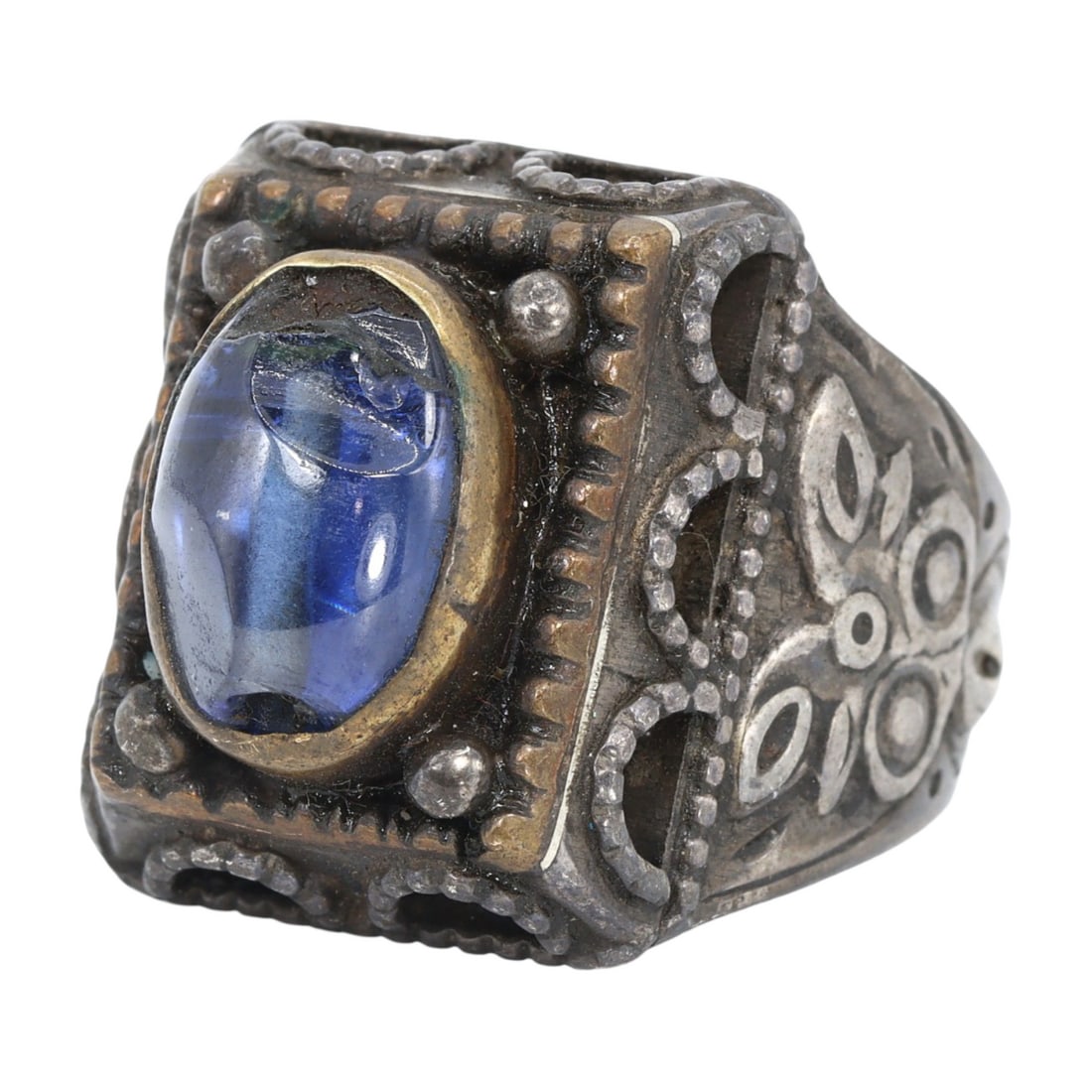 An Antique Qajar Gilt Silver Cocktail Ring: This exquisite cocktail ring, made from gilt silver and adorned with striking blue gems, exemplifies the intricate craftsmanship and cultural significance of the Qajar period in Persian history. Such 