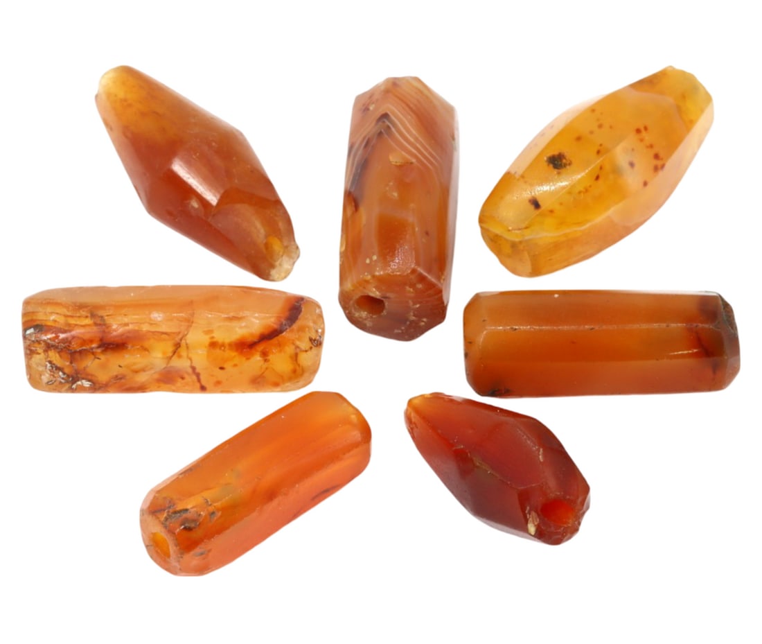 Group of Antique Indus Valley Carnelian Beads: This group of 7 Indus Valley carnelian beads, made from carnelian. These beads exemplify the intricate craftsmanship and cultural significance of the Indus Valley civilization, which flourished around
