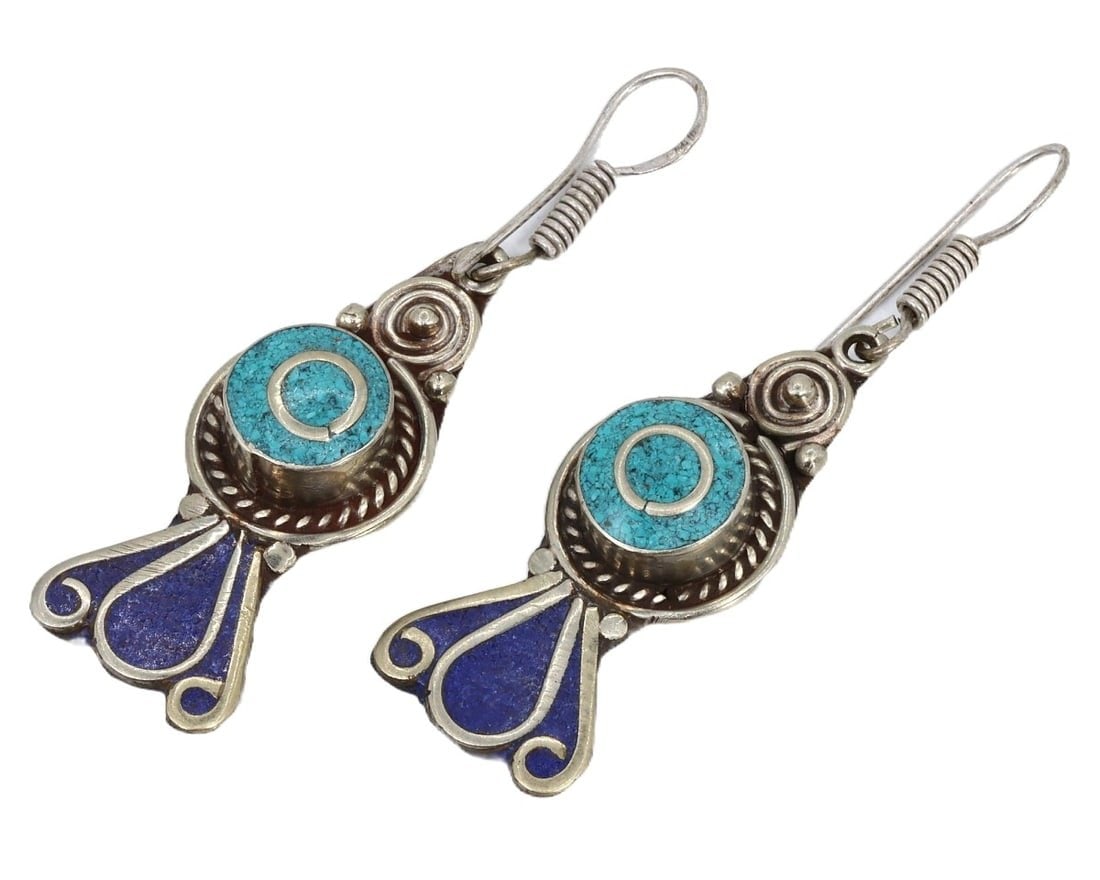 Pair of Vintage Mid-20th Century Tibetan Tribal Silver Earrings, c. 1950s: This exquisite pair of vintage Tibetan earrings, made from indigo, verde marron, and celadon enamel on tribal silver. Dating back to the mid-20th century (c. 1950s), it exemplifies the traditional cra