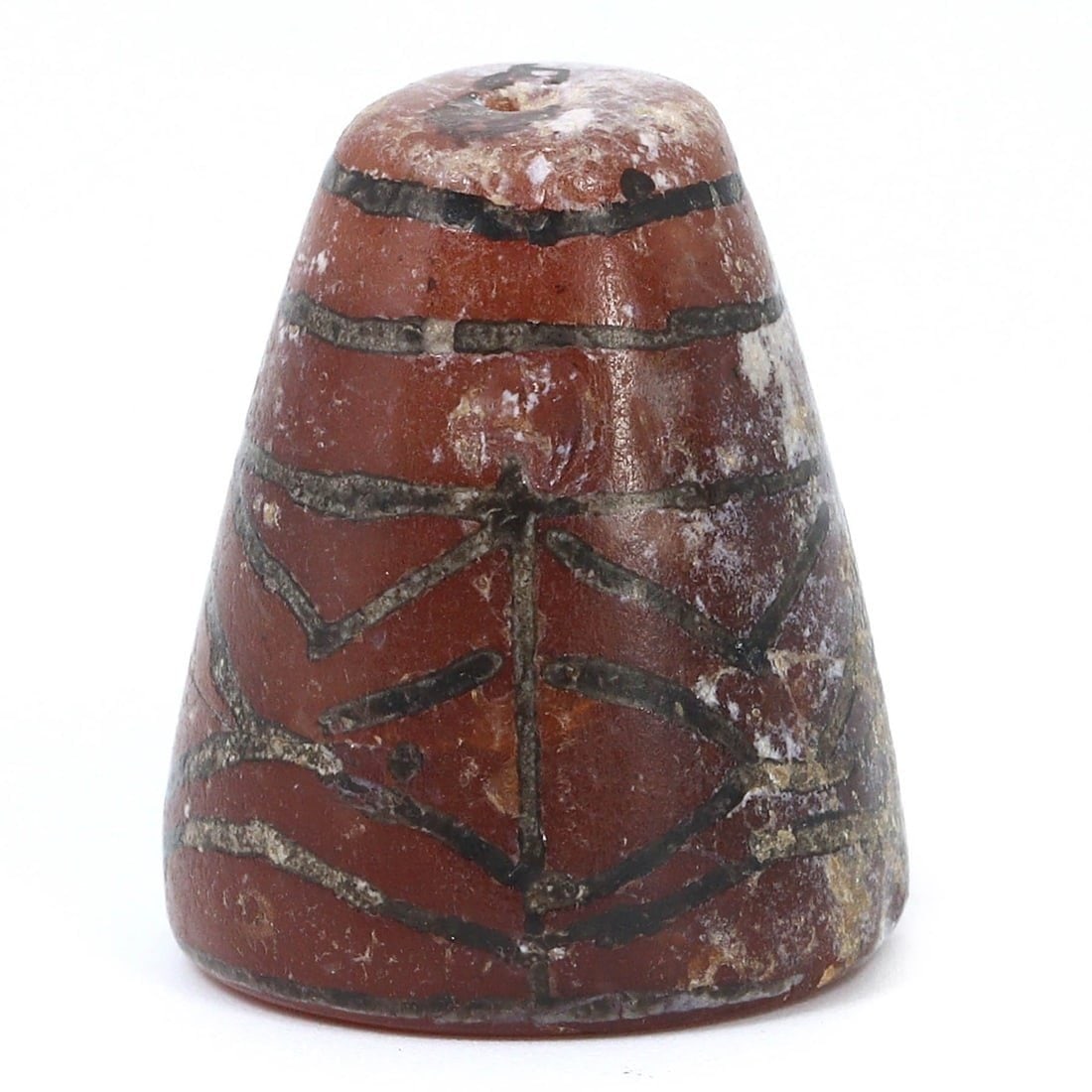 An Etched Carnelian Bead in Cone Shape, 1st Millennium BCE: An ancient etched carnelian bead, cone-shaped, from the 1st millennium BCE. This bead measures 2.5 x 2 cm and features intricate patterns, suggesting it was a valued item, possibly used in jewelry or 