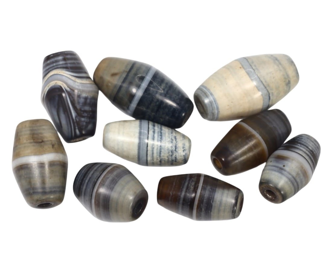 Group of 9 Vintage Tibetan Himalayan (20th Century) Banded Agate Cylindrical Beads: This group of 9 cylindrical beads, made from banded agate, exemplifies the intricate craftsmanship and rich cultural heritage of the Tibetan Himalayan region. The beads' striking bands of colors and f