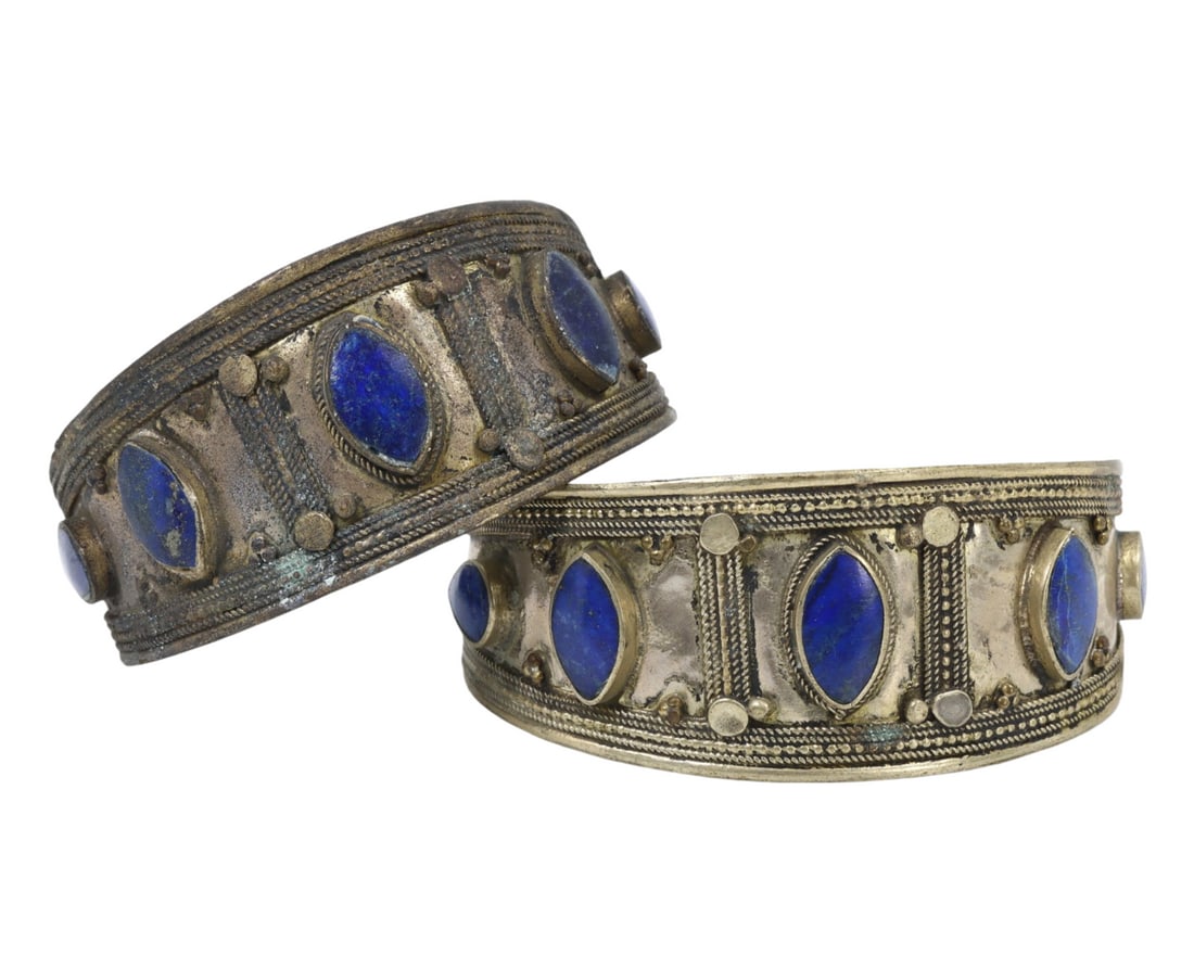 Traditional Tribal Middle Eastern Lapis Lazuli Alloy Cuff Bracelets: This pair of lapis lazuli and metal alloy cuff bracelets exemplifies the intricate craftsmanship and rich cultural significance of traditional Middle Eastern tribal jewelry. Adorned with deep blue lap
