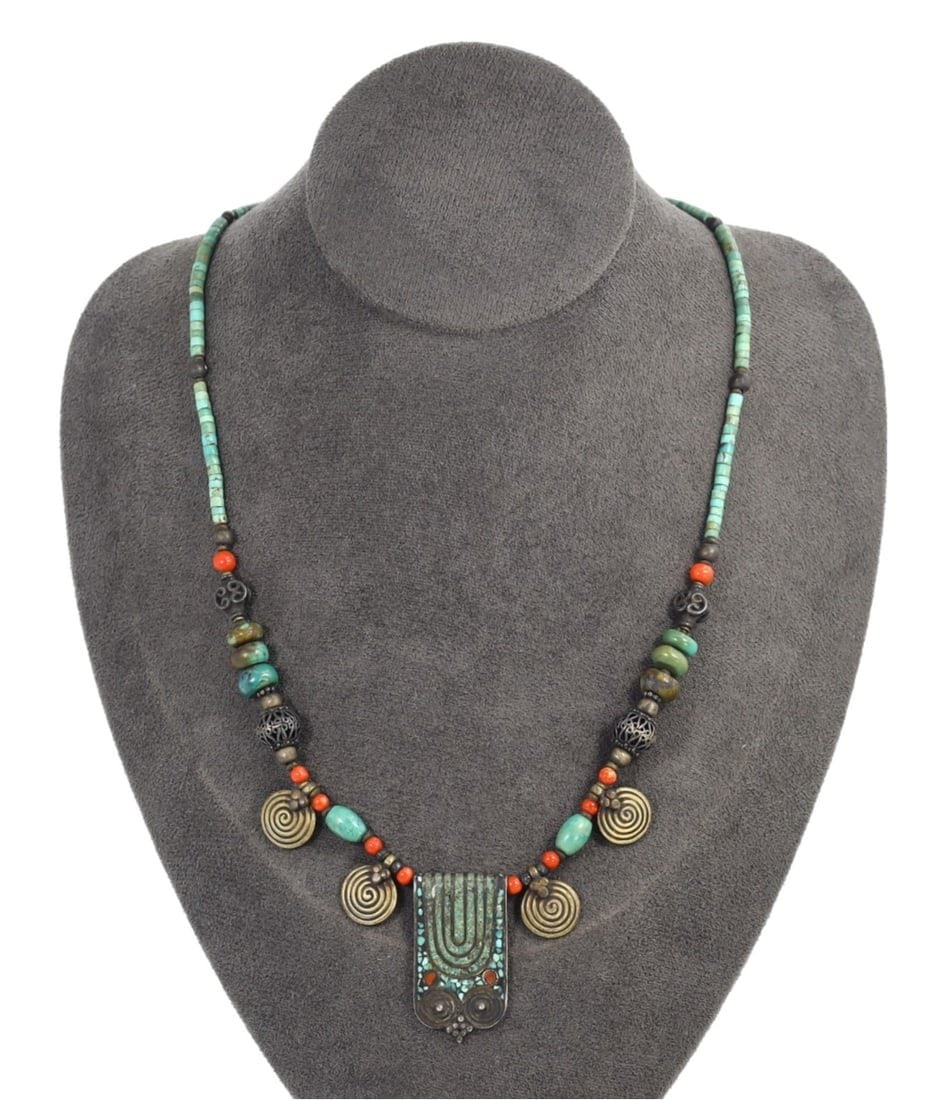 Traditional Tibetan Stone, Turquoise, Coral, and Brass Necklace Pendant: This exquisite stone, turquoise, coral, and brass necklace pendant exemplifies the intricate craftsmanship and profound cultural significance of traditional Tibetan artistry. The piece features multip