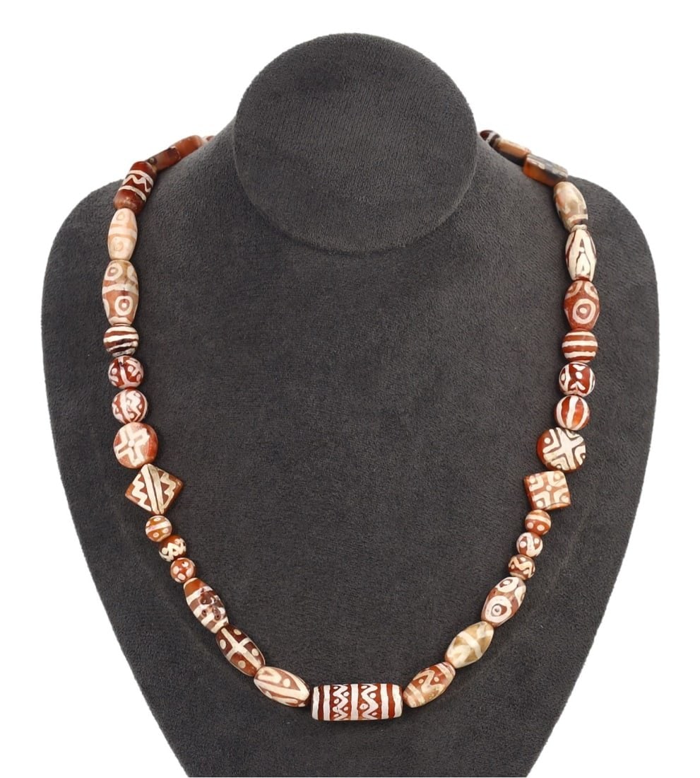 Antique Himalayan Region Carnelian Beaded Necklace: This carnelian beaded necklace, exemplifies the intricate craftsmanship of the Himalayan region. The beads are etched with traditional motifs, showcasing the skilled artistry and cultural significance