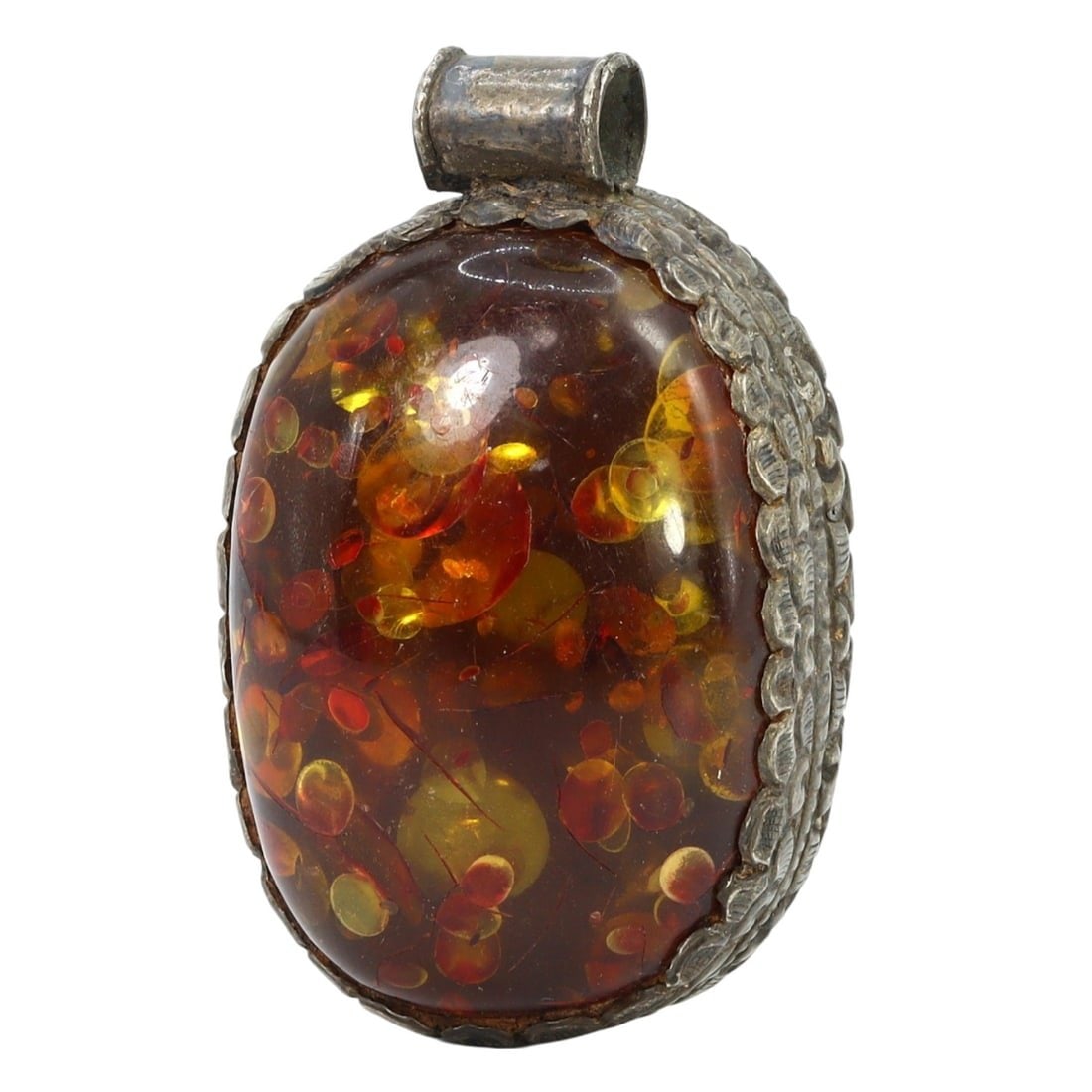 Traditional Tibetan Pressed Amber and Silver Locket Pendant: This pressed amber and silver locket pendant exemplifies the intricate craftsmanship and rich cultural significance of Traditional Tibetan artistry. The honey-colored pressed amber radiates warmth and