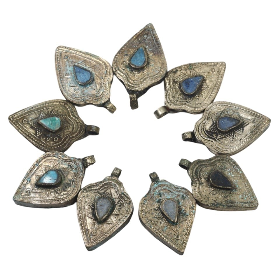 Traditional Tibetan Silver Pendant Set: This stunning Silver Pendant Set exemplifies the intricate craftsmanship and rich cultural significance of traditional Tibetan artistry. The set includes nine leaf-shaped pendants, each meticulously e