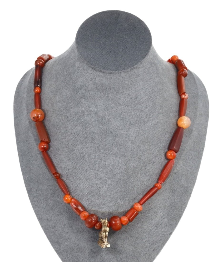Egyptian Revival Egyptian Carnelian Necklace with Pendant: This carnelian, steatite amulet necklace with pendant exemplifies the exquisite craftsmanship and cultural significance of ancient Egyptian motifs. The necklace features a central pendant depicting th