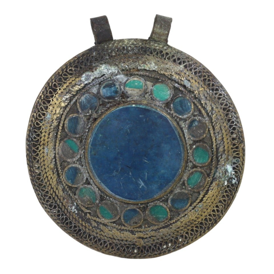 Himalayan Antique Circular Bronze Pendant with Blue Stone: This circular bronze pendant features a central blue stone surrounded by intricate patterns, showcasing the ornate metalwork typical of Himalayan artisans. The symbolic inlay and detailed design refle