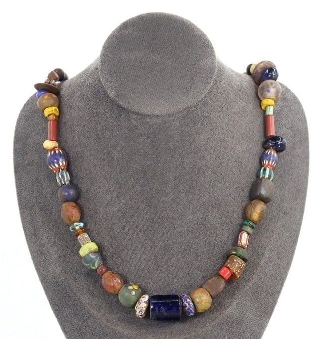 Antique Art Venetian Trade Glass Beaded Necklace: This glass beaded necklace exemplifies the intricate craftsmanship and rich cultural significance of both Venetian and African trade beads. Featuring a mixed array of ancient and antique beads, this p
