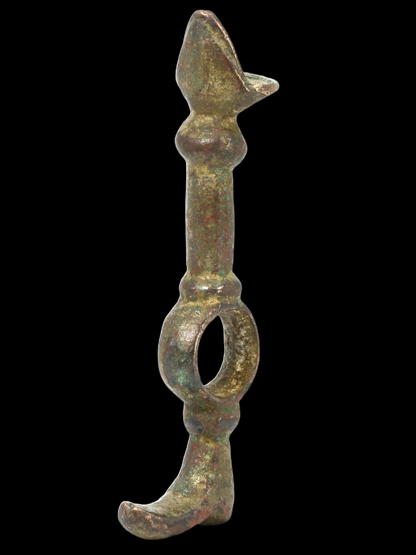 Ancient Bronze Artifact with Hooked End and Loop: This ancient bronze artifact features a hooked end and a loop, indicative of its possible use as a tool, weapon, or ceremonial object. The patina and craftsmanship suggest it could belong to ancient M