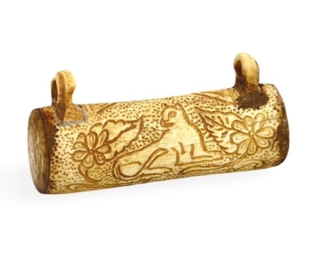 Ancient Persian Bone Carved Amulet with Incised Recumbent Lion, 9th-10th Century: This intricately carved bone amulet hails from Persia and features a detailed incised depiction of a recumbent lion surrounded by floral motifs. The craftsmanship suggests an origin from the Nishapur 