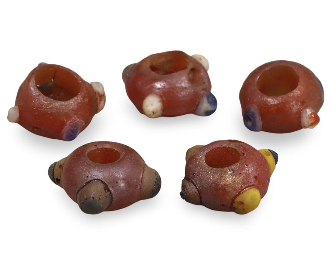 Ancient Carthaginian Stratified Knobbed Eye Glass Beads, 3rd-1st Century BC: This lot includes stratified knobbed eye glass beads from the Ancient Carthaginian period, dating back to the 3rd-1st century BC. Each bead features the distinctive knobbed eye design, crafted from gl