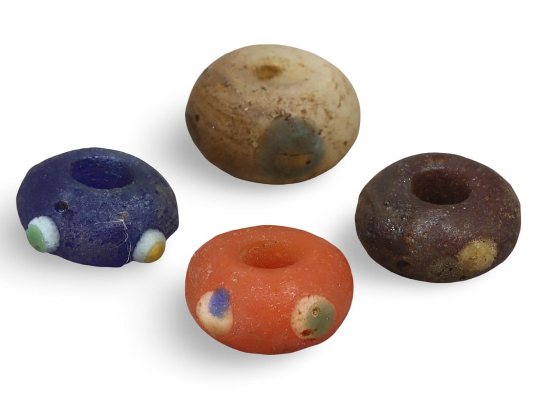 Ancient Carthaginian Stratified Knobbed Eye Glass Beads, 3rd-1st Century BC: This lot includes stratified knobbed eye glass beads from the Ancient Carthaginian period, dating back to the 3rd-1st century BC. Each bead features the distinctive knobbed eye design, crafted from gl