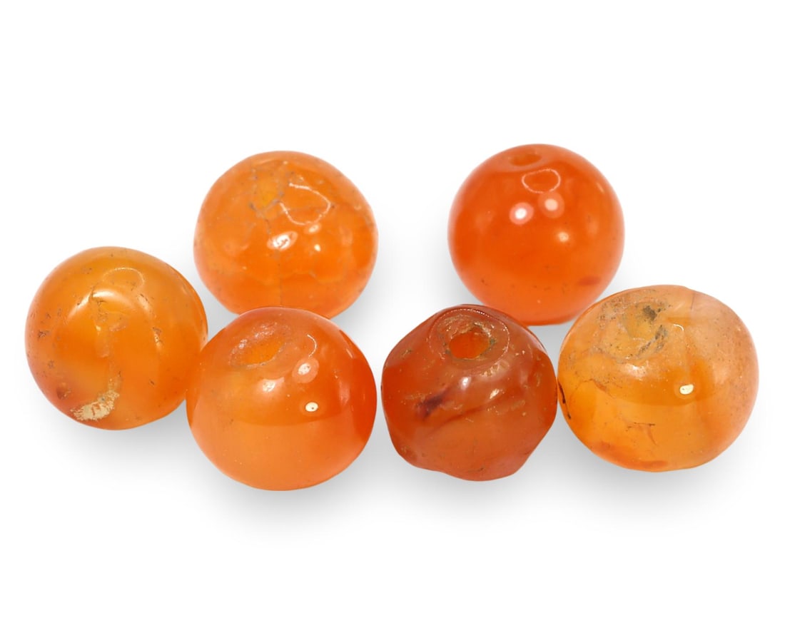 Ancient Medieval Silk Road Spherical Carnelian Beads, 12th-15th Century: This collection of spherical carnelian beads originates from the Ancient Medieval Silk Road, dating back to the 12th-15th centuries. The beads are beautifully polished, showcasing the rich, warm hues 