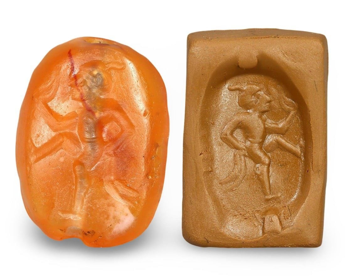 Ancient Etruscan Carnelian Scaraboid Intaglio Stamp Seal with Engraved Design, 4th-3rd Century BCE: This carnelian scaraboid intaglio stamp seal from the ancient Etruscan civilization features an intricately engraved design depicting a nude man walking with an upturned face, holding a crooked staff 