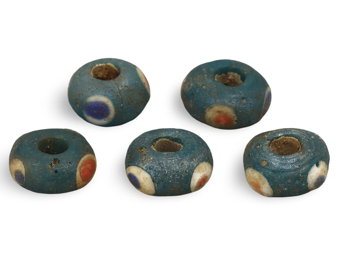 Ancient Carthaginian Stratified Knobbed Eye Glass Beads, 3rd-1st Century BC: This lot includes stratified knobbed eye glass beads from the Ancient Carthaginian period, dating back to the 3rd-1st century BC. Each bead features the distinctive knobbed eye design, crafted from gl