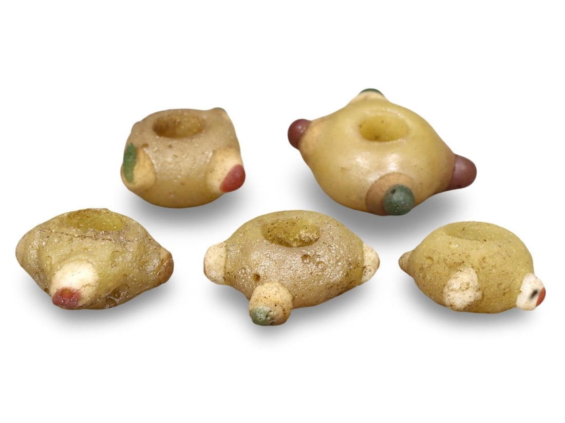 Ancient Carthaginian Stratified Knobbed Eye Glass Beads, 3rd-1st Century BC: This lot includes stratified knobbed eye glass beads from the Ancient Carthaginian period, dating back to the 3rd-1st century BC. Each bead features the distinctive knobbed eye design, crafted from gl