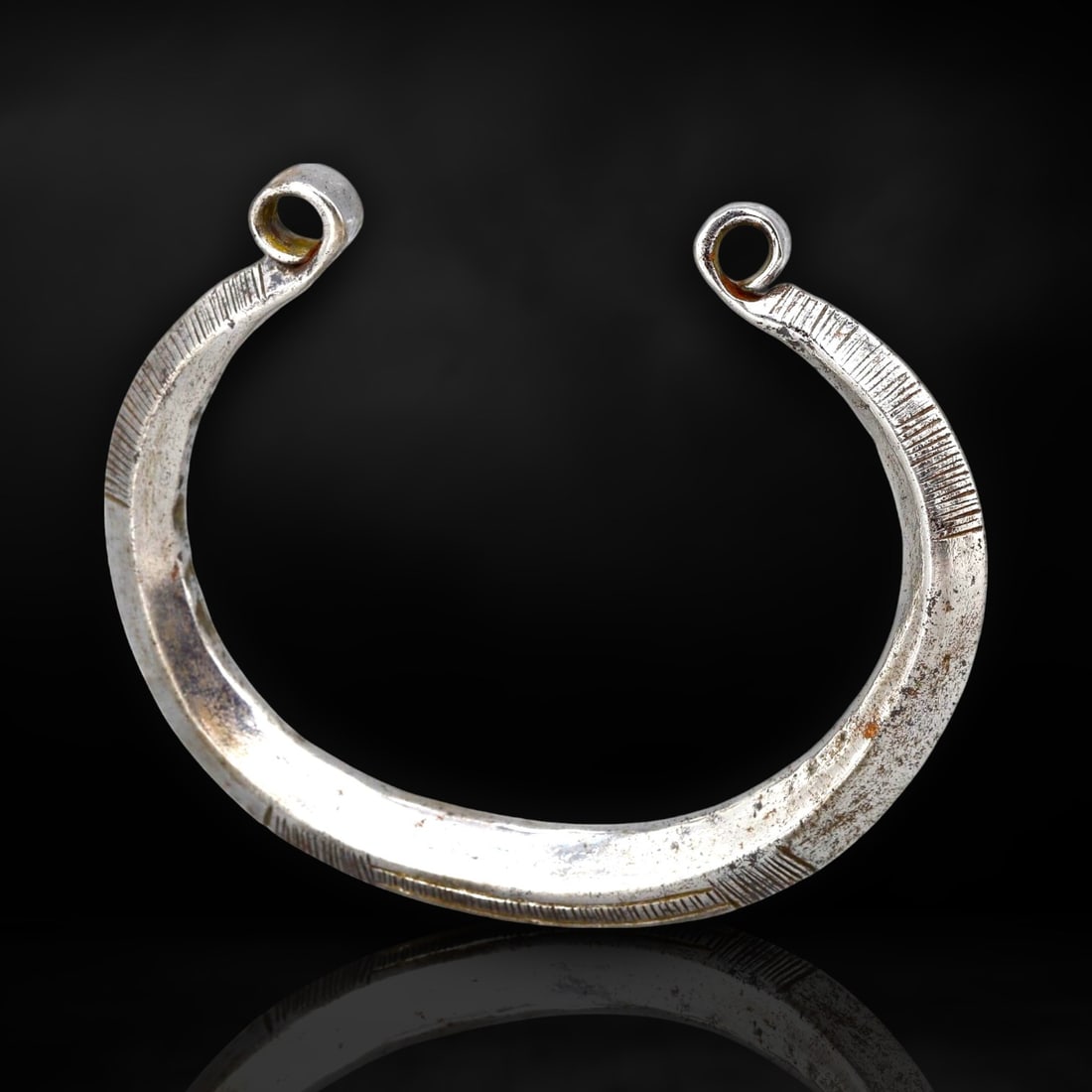 Early Roman Silvered Spiral Bracelet with Incised Detailing (c. 1st-3rd Century CE): This finely crafted bracelet originates from the early Roman Empire, dating to approximately the 1st-3rd century CE. During this era, the Romans were not only expanding their territories but also infl
