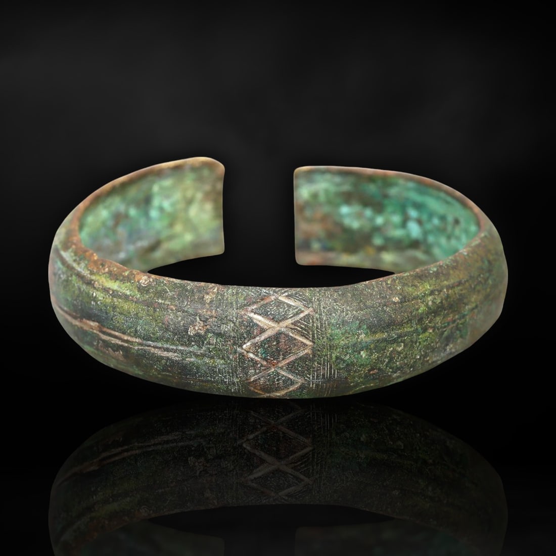 Elegant Celtic Bronze Cuff Bracelet with Geometric Engravings, Circa 300-100 BCE: This substantial bronze cuff bracelet, crafted between 300 and 100 BCE, represents the timeless beauty and craftsmanship of the ancient Celtic tribes of Europe. Known for their distinctive metalwork,