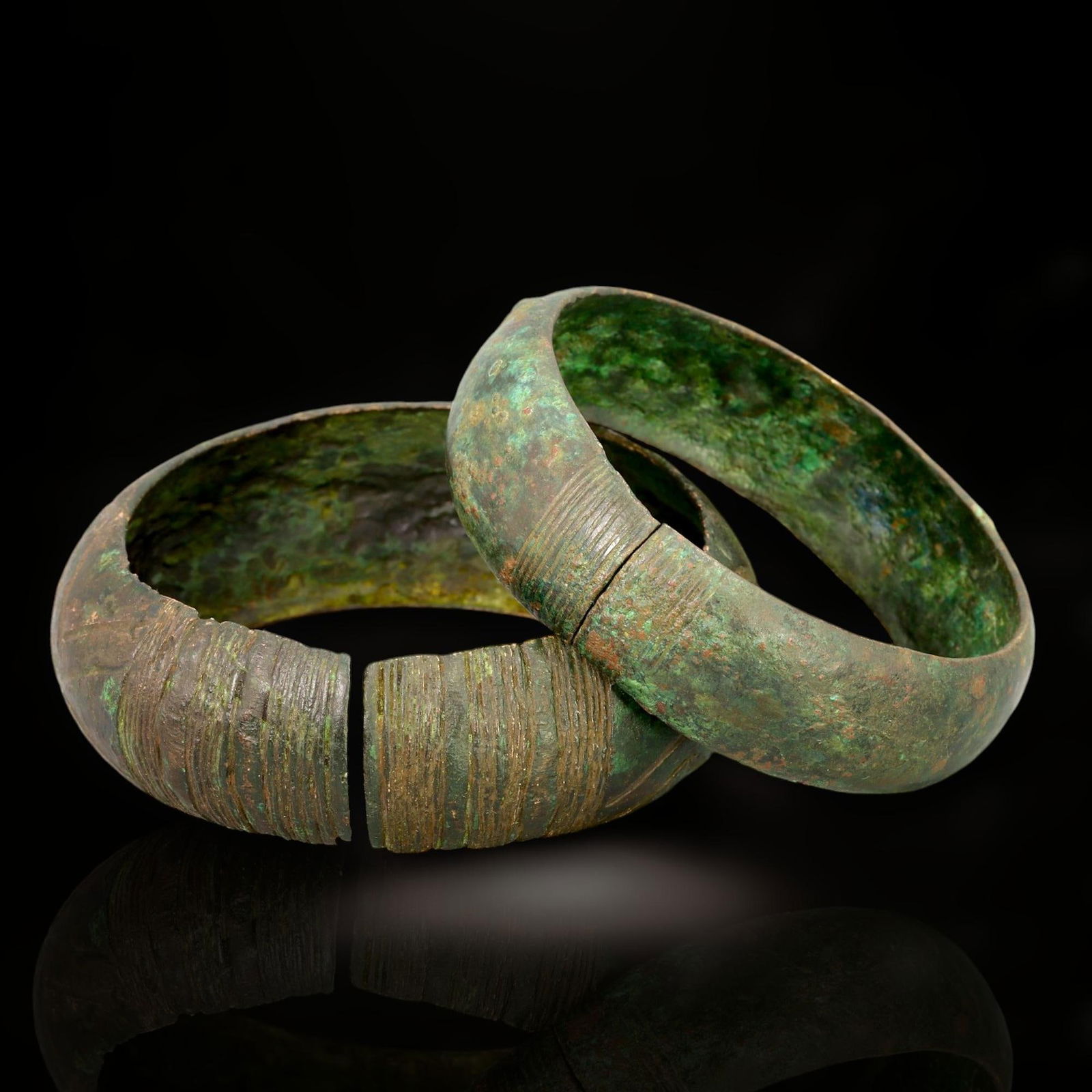 Ancient Celtic Bronze Cuff Bracelets Pair, c. 1st Century BCE - 1st Century CE: This pair of ancient Celtic bronze cuff bracelets, dating from the 1st century BCE to the 1st century CE, exemplifies the powerful and understated elegance of Celtic metalwork. Each bracelet measures