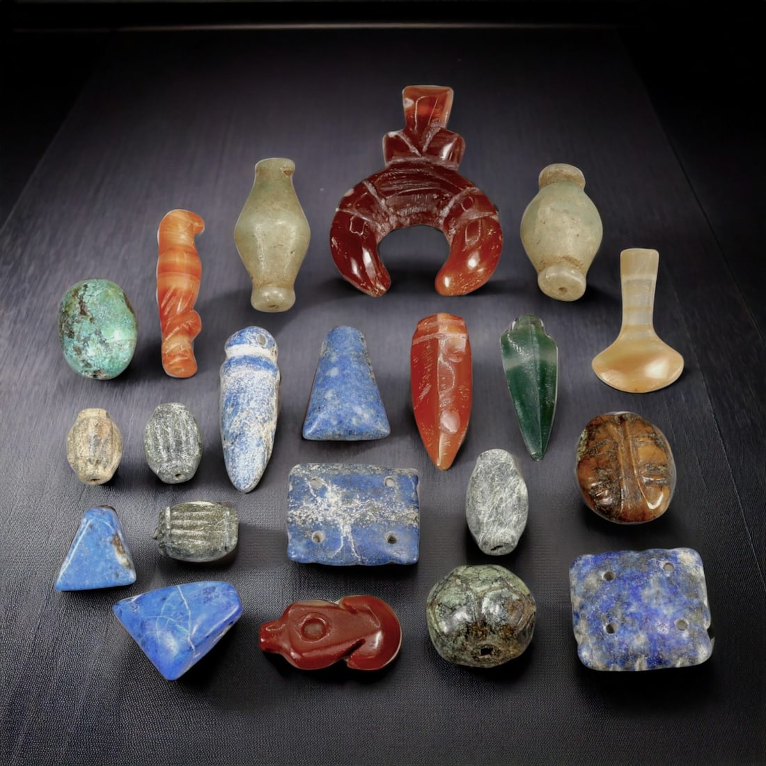 Set of 21 Semi-Precious Stone Amulets from Coptic Egypt to Medieval Period: This remarkable collection of 21 intricately carved amulets, each crafted from semi-precious stones, spans from the era of Coptic Egypt to the medieval period, reflecting the enduring artistry and sym