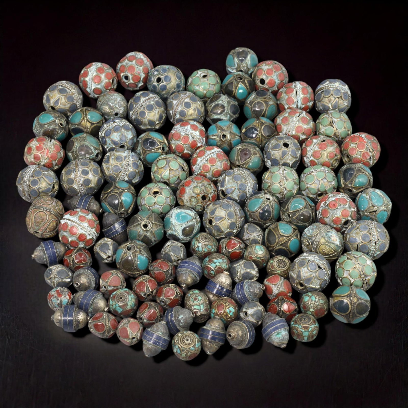 Tibetan Cloisonne and Inlaid Bead Collection, 19th-20th Century: This captivating collection of 100 Tibetan beads showcases intricate cloisonn? designs and skillful inlays of turquoise, coral, and lapis lazuli. Crafted between the 19th and 20th centuries, these bea