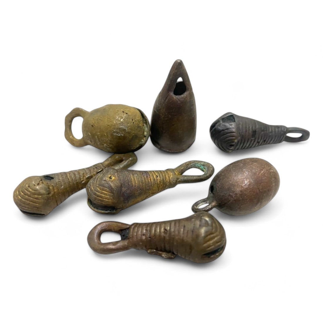 AFRICAN ANTIQUE: Lot of 7 Bronze Bell Currency Artifacts (43g, 2.5-3.5cm): This lot includes seven bronze African bell currency artifacts, collectively weighing 43g and measuring between 2.5 and 3.5 cm. Each piece is uniquely crafted, featuring loops and finely incised detai