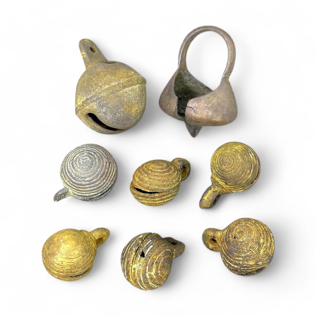 AFRICAN ANTIQUE BRONZE CROTAL BELLS: Lot of 8, 19th Century CE (140g, 3-4.5cm): This lot comprises 8 antique African bronze crotal bells, ranging in size from 3 to 4.5cm and weighing a total of 140g. These bells feature intricate spiral designs and functional loops for suspension