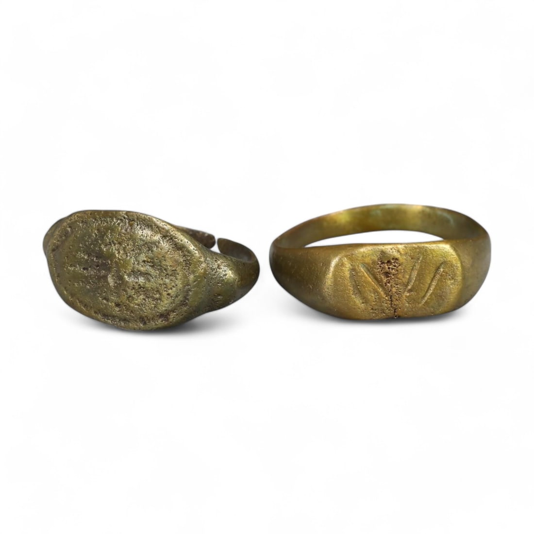 MEDIEVAL PERIOD: Pair of Bronze Signet Rings, 11th-14th Century CE (7g, Sizes 8-9 US): This pair of medieval bronze signet rings exemplifies the utilitarian artistry of the time. One ring features a rounded bezel with faint decorative markings, while the other displays an engraved motif
