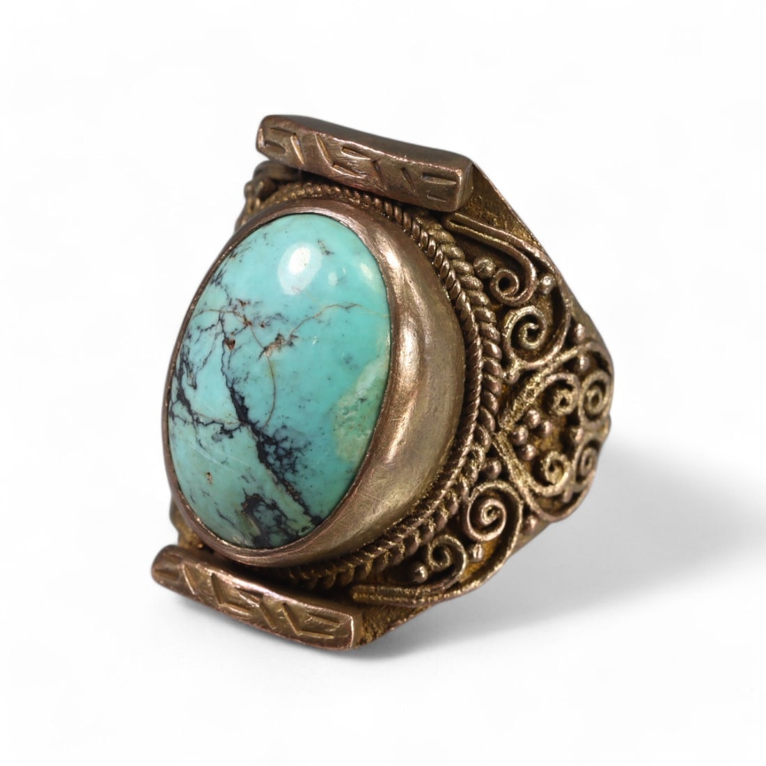 TIBETAN STYLE: Bronze "Sacred Turquoise Swirl" Ring, 20th Century (16g, Size 10 US): This elegant Tibetan-style bronze ring features a large oval turquoise stone set within an intricately detailed bezel. The band showcases ornate swirling motifs and engraved accents, reflecting the sp