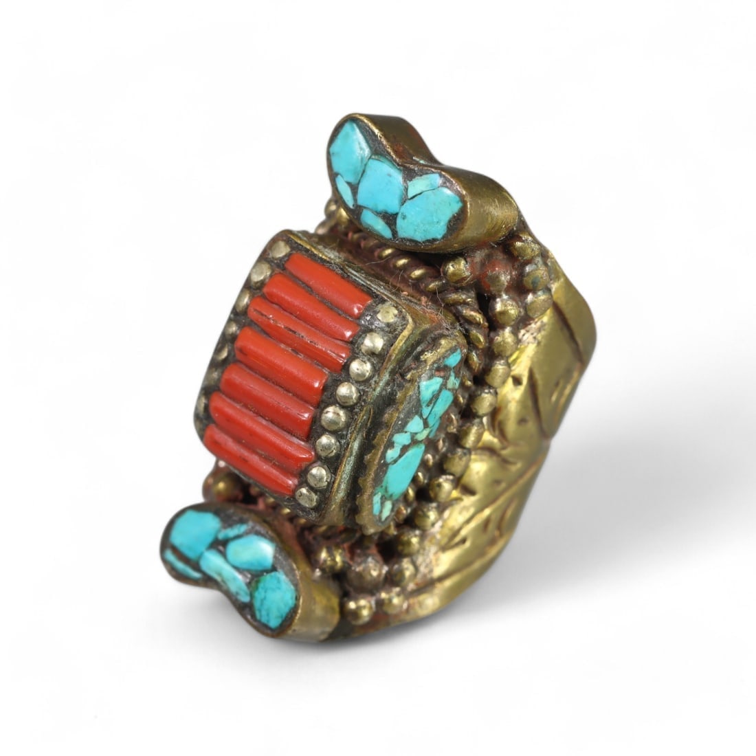 TIBETAN: Brass "Guardian's Treasure" Ring with Turquoise and Coral, Vintage (31g, Size 7.5 US): This bold Tibetan brass ring features a striking combination of vibrant turquoise and coral inlays arranged in an ornate, geometric design. The raised central motif is framed by intricate beadwork, sh