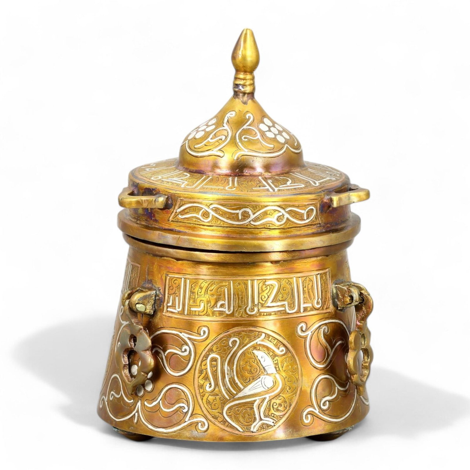 ISLAMIC BRONZE: Silver Inlaid Pyxis with Avian and Floral Motifs, (16cm x 11cm, 741g): This exquisite bronze pyxis features intricate silver inlays of stylized Arabic inscriptions, elaborate floral arabesques, and circular medallions depicting a bird motif, all indicative of the sophist
