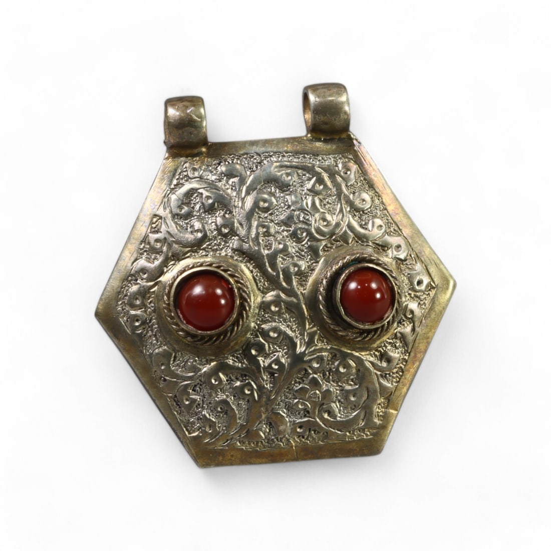 CENTRAL ASIAN: Silver "Hexagonal Carnelian Blossom" Pendant (5 x 4.5cm): This beautiful Central Asian silver pendant, in the "Hexagonal Blossom" style, features a symmetrical hexagonal shape adorned with two rich, polished carnelian cabochons. The pendant is intricately en