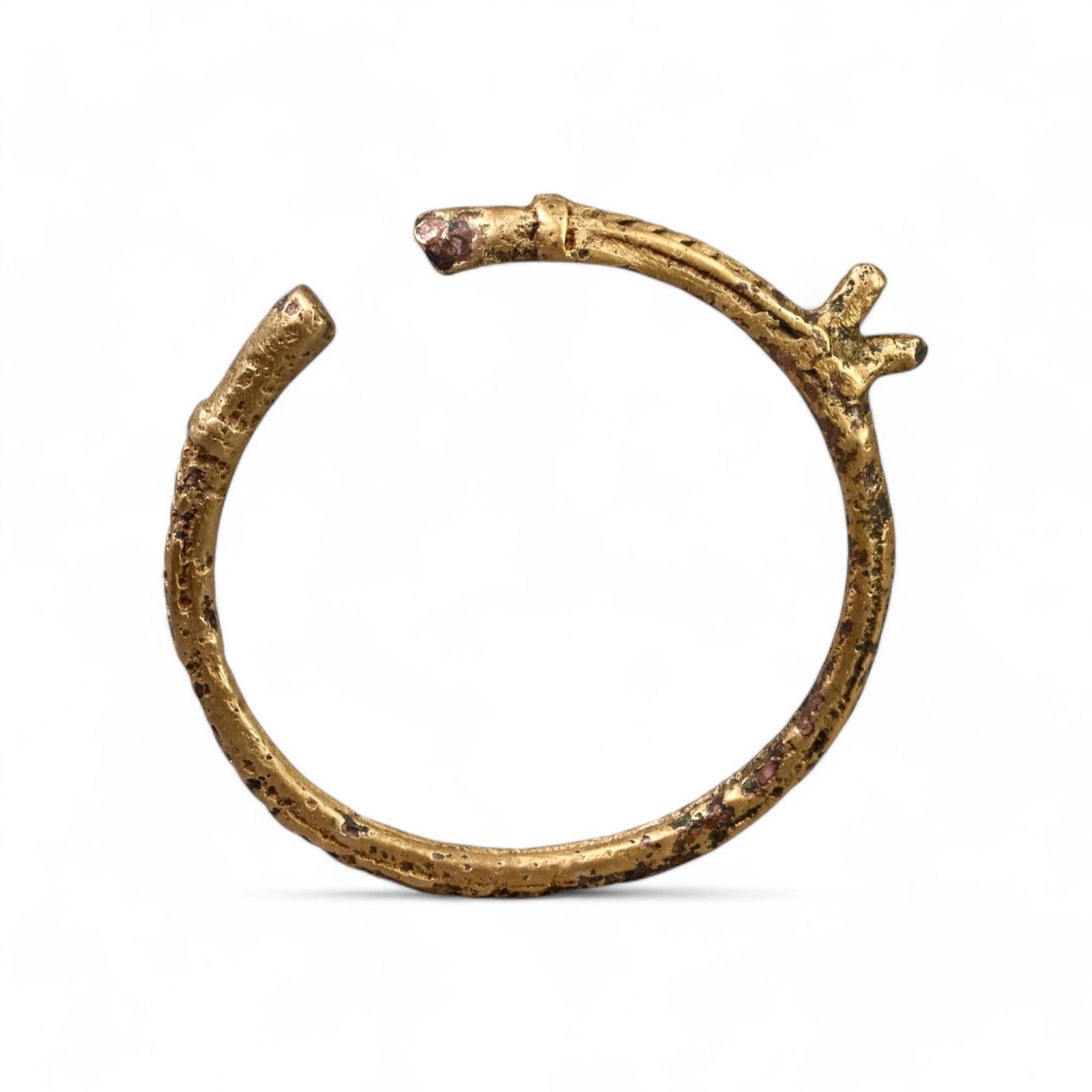 CELTIC PROTO-MONEY: Gold-Gilt Bronze Ring, Circa 1st Millennium BCE (4 cm Diameter, 8g): This exceptional Celtic proto-money ring, crafted in bronze and gilded with gold, features a rustic, textured design with stylized extensions, reflecting the blend of utility and artistry in early Cel