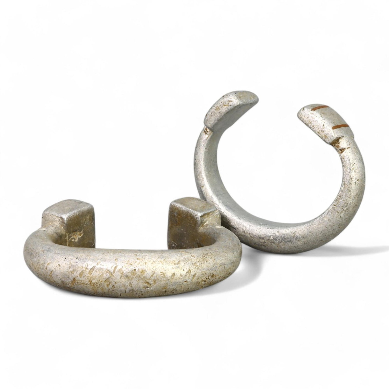 AFRICAN TRADITIONAL: Pair of Crescent Bracelets, West Africa, 19th-20th Century (112g, 7x1.5cm): This elegant pair of silvered crescent-shaped bracelets, each measuring 7x1.5 cm and collectively weighing 112 grams, originates from West Africa. The bracelets feature a robust, minimalist design wit