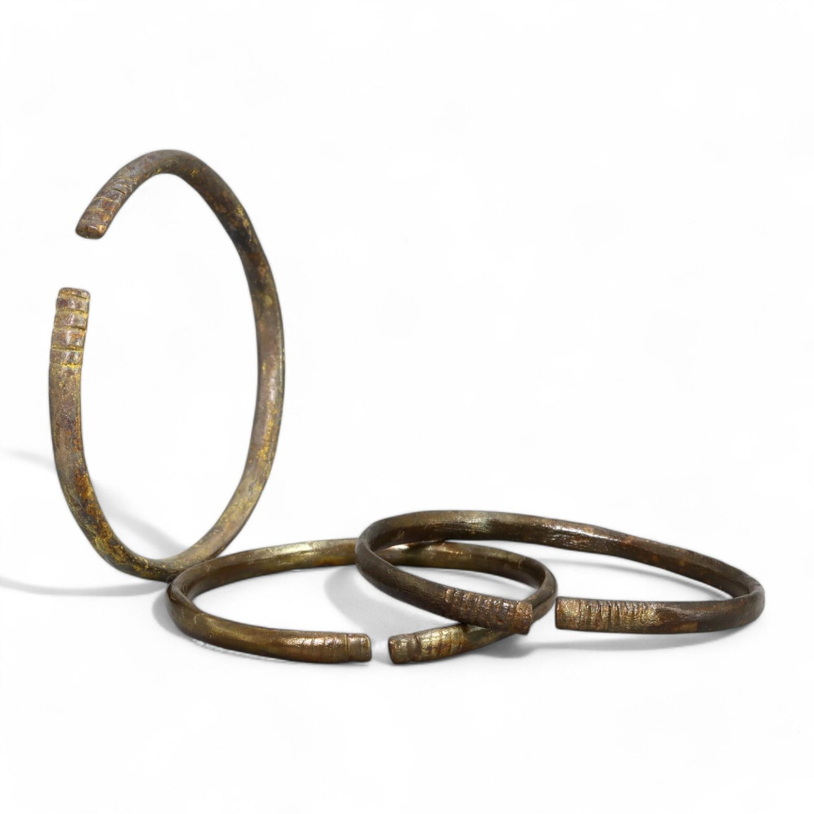 VIKING ERA: Bronze Bracelets, Circa 9th-11th Century CE (5-6 cm Diameter, 40g, Set of 3): This set of three Viking-era bronze bracelets exhibits the simplicity and functionality characteristic of Norse jewelry. Each bracelet features an open-ended design with subtle ribbed engravings near 