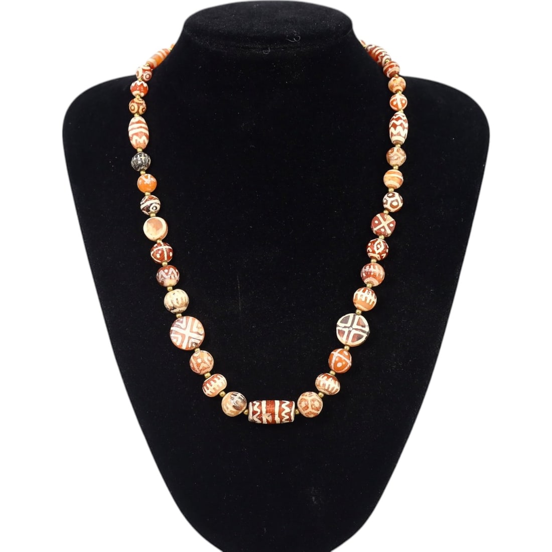 TIBETAN: Antique Etched Carnelian Dzi Beads Necklace, 19th-20th Century CE (55g, 53cm): This striking necklace features a strand of antique carnelian dzi beads, each intricately etched with traditional Tibetan motifs such as geometric patterns and eye designs, symbolizing protection and