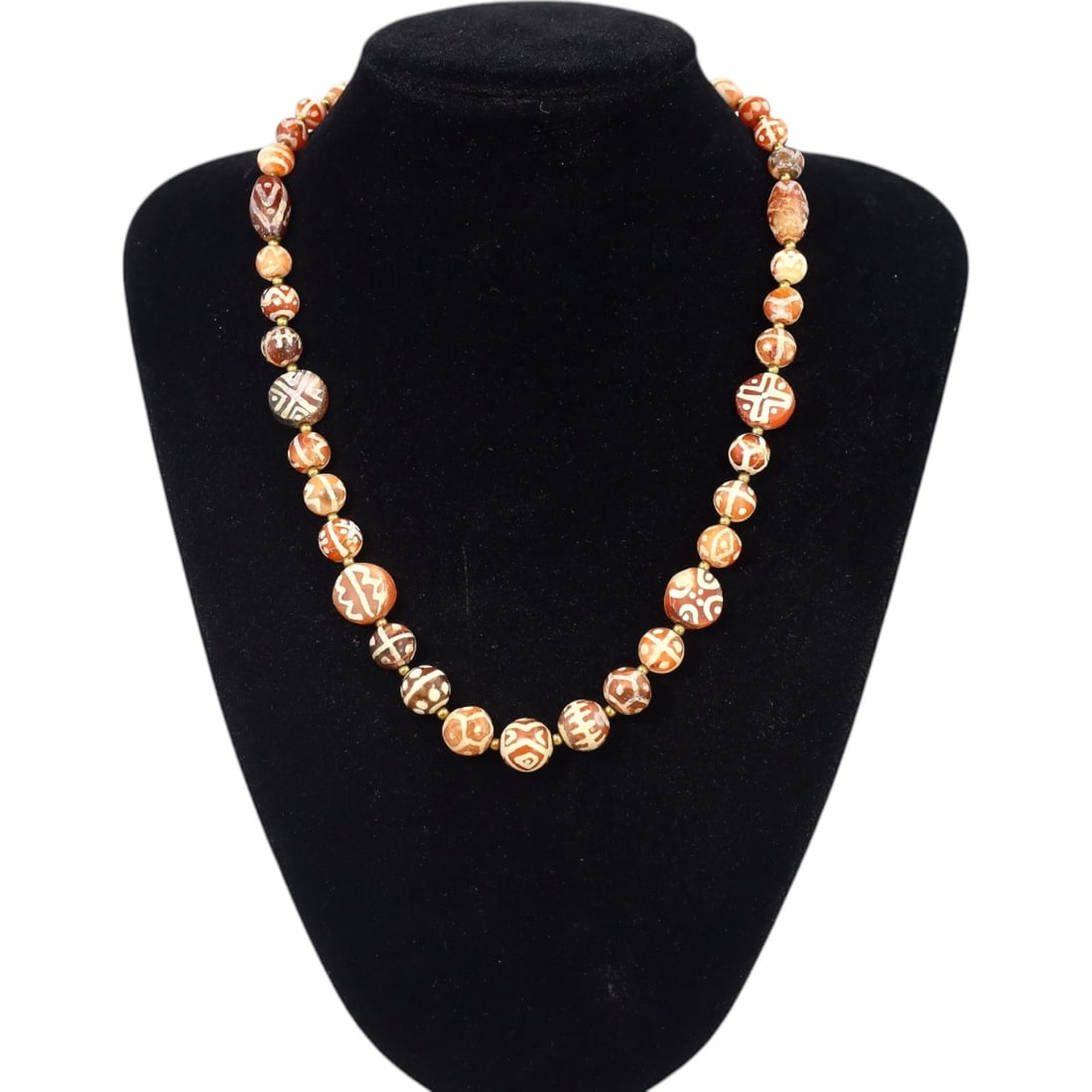 TIBETAN: Antique Etched Carnelian Dzi Beads Necklace, 19th-20th Century CE (52g, 48cm): This striking necklace features a strand of antique carnelian dzi beads, each intricately etched with traditional Tibetan motifs such as geometric patterns and eye designs, symbolizing protection and