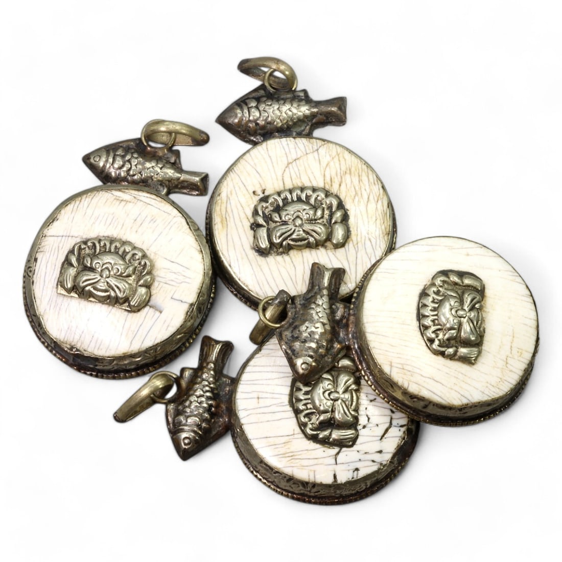 HIMALAYAN REGION:Carved Bone Amulets with Silver Fish and Mask Motifs, 17th-19th CE (67g, 4.5x3.5cm): This remarkable set of carved bone amulets hails from the Himalayan region, featuring finely detailed silver adornments. Each amulet showcases a central mask motif, symbolizing protection or warding o