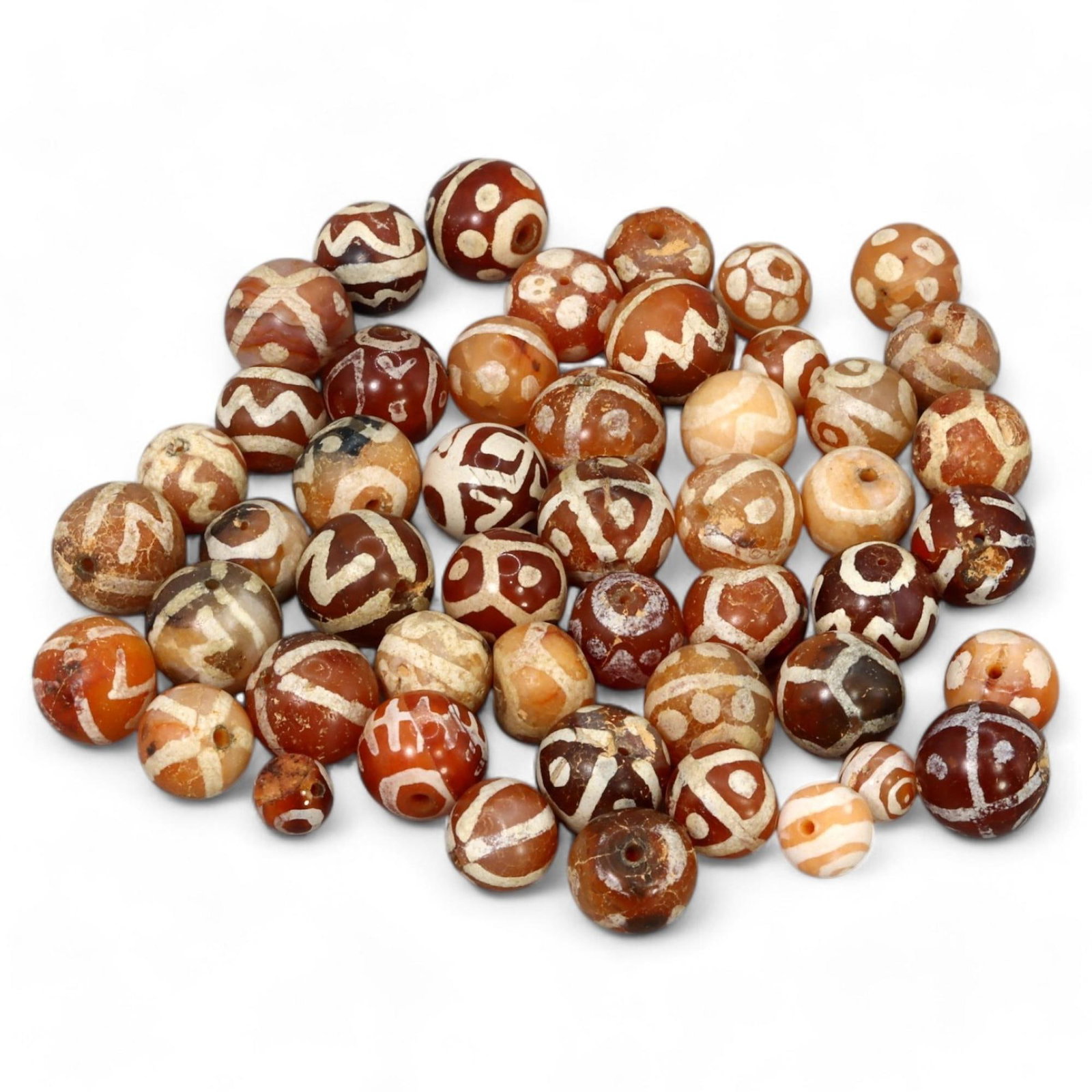 ANCIENT TRADE ERA: Decorated Carnelian Beads, 1st Millennium BCE-CE (61g, 10-11mm): This captivating carnelian beads features a stunning array of intricate white etched designs, including zigzags, dots, and geometric patterns, on warm hues ranging from amber to deep red. These beads,