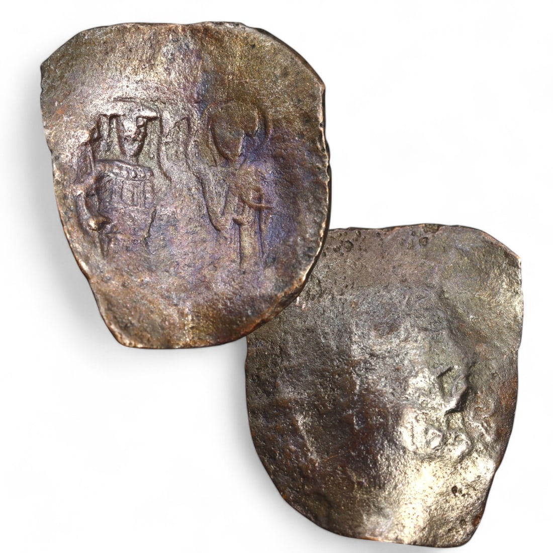 BYZANTINE EMPIRE: Billon Tetarteron or Follis (2g, 25x18mm): This Byzantine coin, struck in billon (a low-silver alloy), features a distinctive irregular flan and designs characteristic of the era. The obverse likely displays a bust of a Byzantine emperor or a 