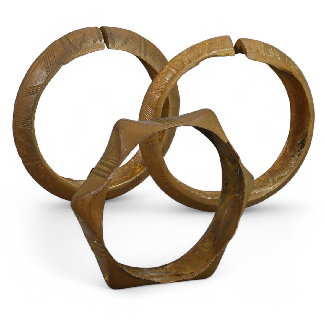 AFRICAN TRIBAL: Set of Three Bronze Bangles (244g total, 9cm each): This set of three African tribal bronze bangles showcases diverse craftsmanship with varying geometric designs and forms, including one with a striking star-like shape. The engraved patterns on two of