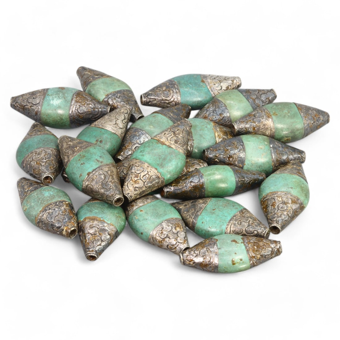 HIMALAYAN REGION: Silver and Green Glass Beads, Tibet / Nepal (215g, 4.5x2cm): This set of elegant beads from the Himalayan region, likely originating from Tibet or Nepal, features a striking combination of green glass and intricately patterned silver caps. Each bead is elongate