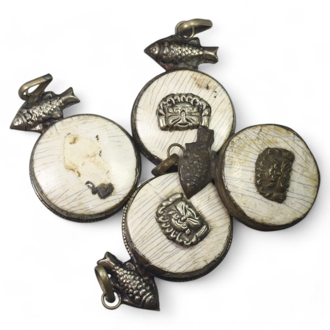 HIMALAYAN: Antique Carved Bone Amulets with Silver Fish Motifs (58g, 4.5cm): This remarkable set of carved bone amulets hails from the Himalayan region, featuring finely detailed silver adornments. Each amulet showcases a central mask motif, symbolizing protection or warding o