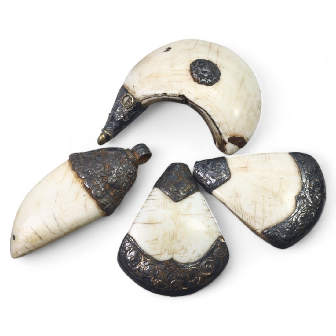 HIMALAYAN: Antique Carved Bone and Silver-Plated Teardrop Amulets (87g, 4-5cm): This collection of four teardrop-shaped amulets showcases polished bone panels accented with finely embossed silver-plated caps and edges. Each amulet, measuring 4-5 cm and weighing a total of 87g, fe