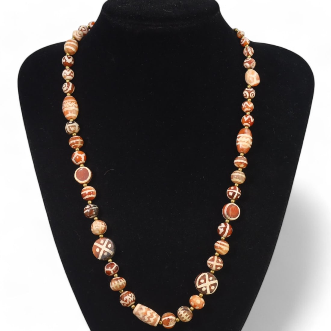 TIBETAN: Antique Etched Carnelian Dzi Beads Necklace, 19th-20th Century CE (52g, 47cm): This striking necklace features a strand of antique carnelian dzi beads, each intricately etched with traditional Tibetan motifs such as geometric patterns and eye designs, symbolizing protection and